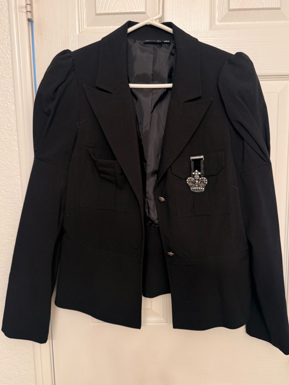 Black Structured Blazer with Decorative Brooch
Waistline flare